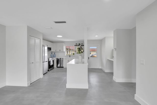 kitchen with white cabinetry, a center island, sink, and appliances with stainless steel finishes