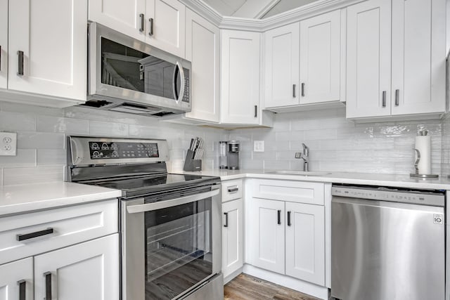 kitchen with white cabinets, appliances with stainless steel finishes, decorative backsplash, and sink