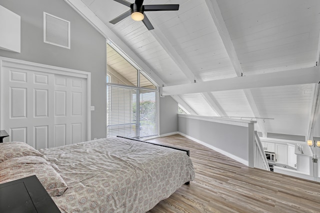 bedroom with hardwood / wood-style floors, ceiling fan, a closet, and lofted ceiling with beams