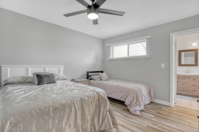 bedroom with ensuite bath, ceiling fan, and light hardwood / wood-style floors