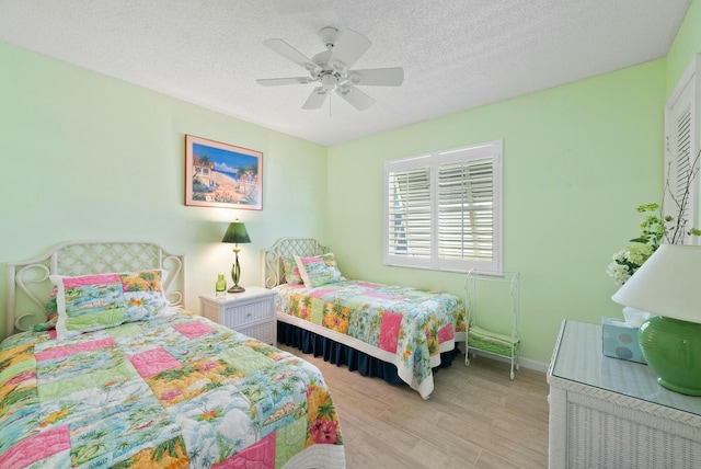 bedroom featuring ceiling fan, a textured ceiling, and light hardwood / wood-style flooring