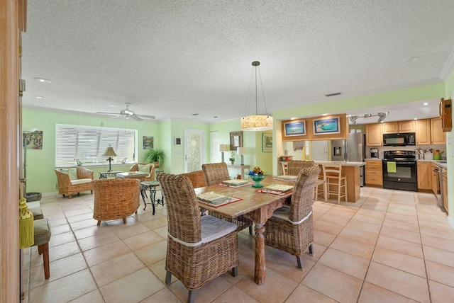 tiled dining area with a textured ceiling and ceiling fan