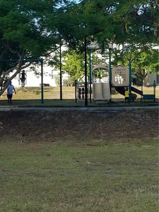 view of community featuring a playground and a lawn