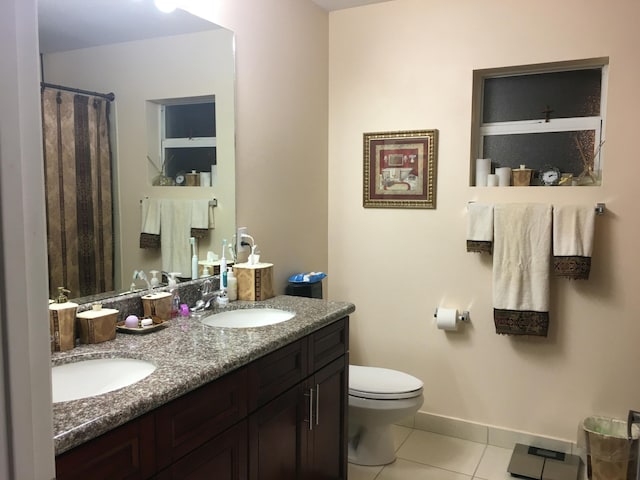 bathroom with tile patterned floors, vanity, toilet, and walk in shower