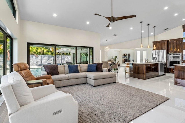 living room with high vaulted ceiling, ceiling fan, sink, and a wealth of natural light