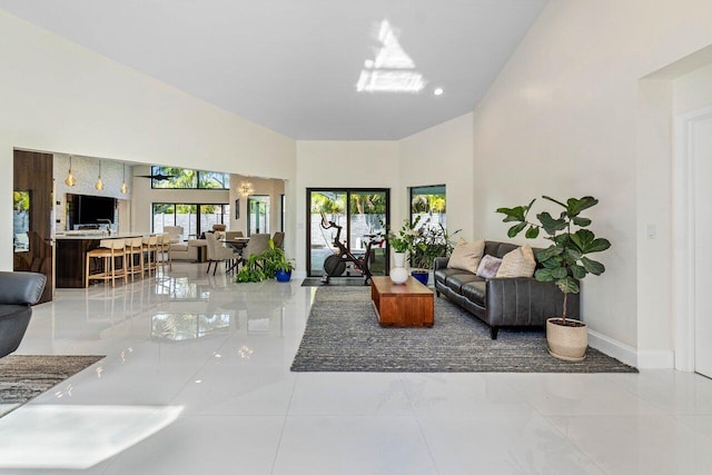 living room with light tile patterned flooring and a towering ceiling