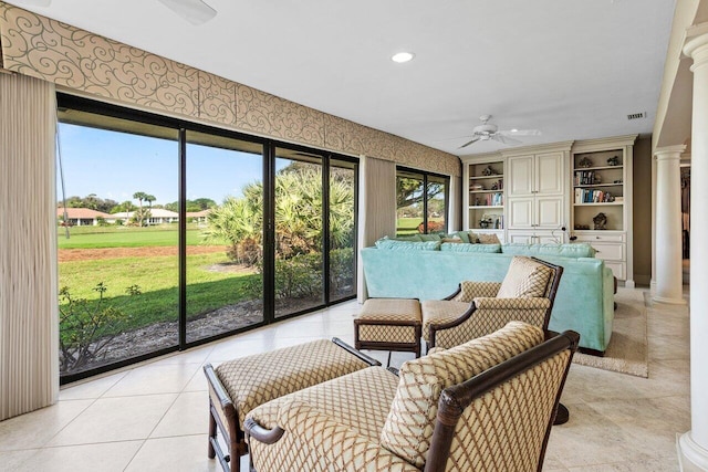 sunroom featuring ornate columns and ceiling fan