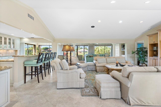 living room with vaulted ceiling and crown molding