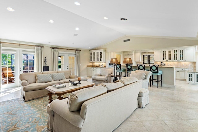 tiled living room featuring french doors, vaulted ceiling, and ornamental molding