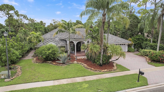 mediterranean / spanish home with a front yard and a garage