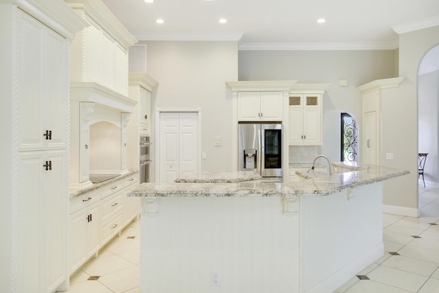 kitchen featuring a large island, light stone counters, backsplash, and appliances with stainless steel finishes