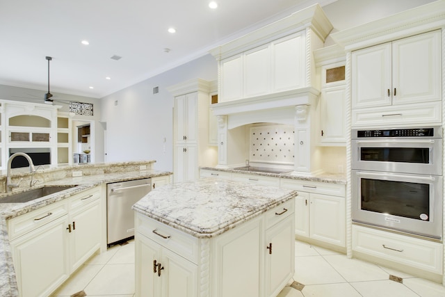 kitchen featuring appliances with stainless steel finishes, light stone counters, sink, a center island, and light tile patterned flooring