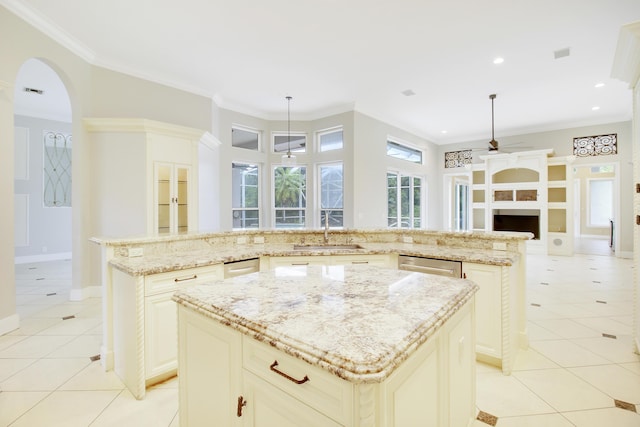 kitchen featuring light stone countertops, a large island, sink, and pendant lighting