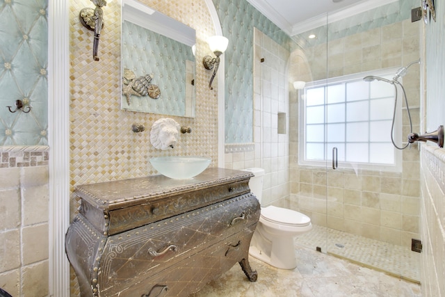 bathroom featuring vanity, a shower with door, crown molding, tile walls, and toilet