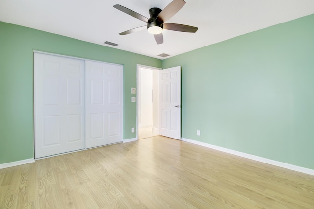 unfurnished bedroom featuring ceiling fan, light wood-type flooring, and a closet