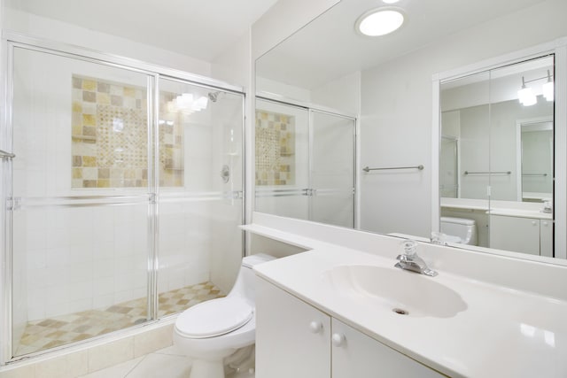 bathroom featuring tile patterned flooring, vanity, a shower with shower door, and toilet