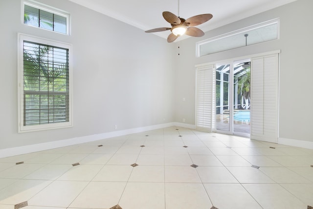 unfurnished room with light tile patterned floors, ceiling fan, and a high ceiling