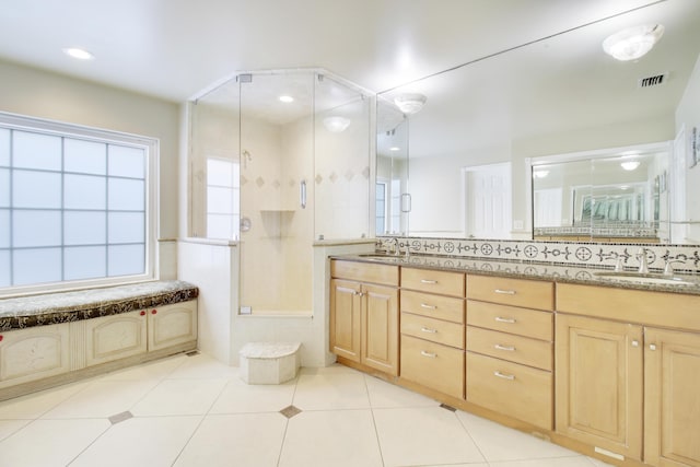 bathroom featuring tile patterned flooring, vanity, and tasteful backsplash