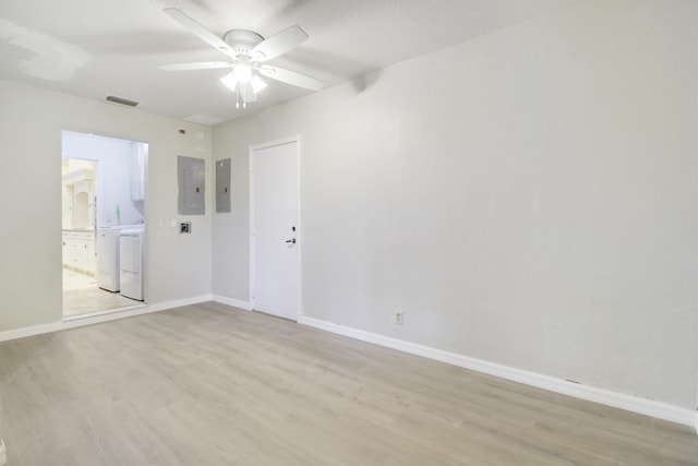 spare room featuring ceiling fan, light wood-type flooring, and electric panel