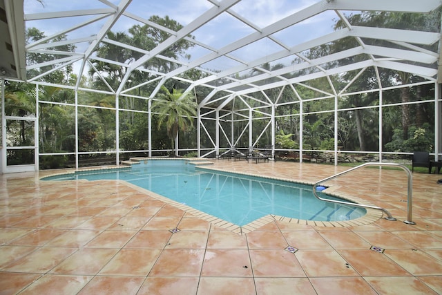 view of swimming pool featuring glass enclosure and a patio