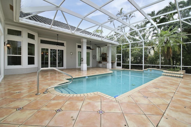 view of swimming pool featuring a patio, glass enclosure, and ceiling fan