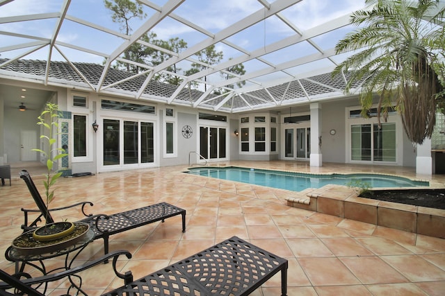 view of swimming pool with ceiling fan, a patio area, and a lanai