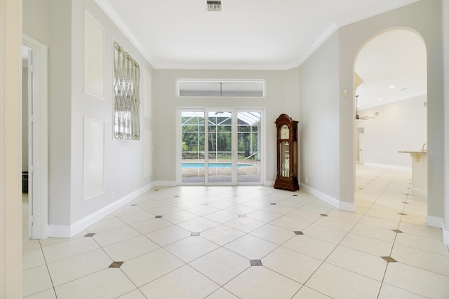 spare room featuring ceiling fan, light tile patterned flooring, and ornamental molding