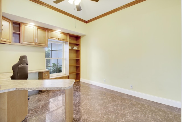 unfurnished office with ceiling fan, built in desk, ornamental molding, and built in shelves