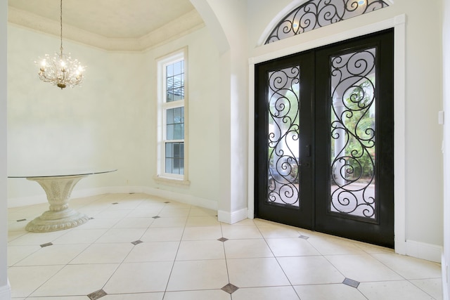 entryway featuring french doors, light tile patterned floors, and an inviting chandelier