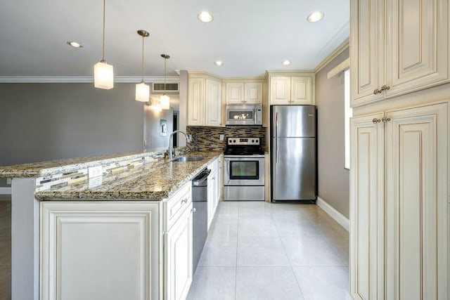 267 Normandy F, Delray Beach, FL 33484 - kitchen with stainless steel appliances, cream cabinetry, a sink, light stone counters, and a peninsula