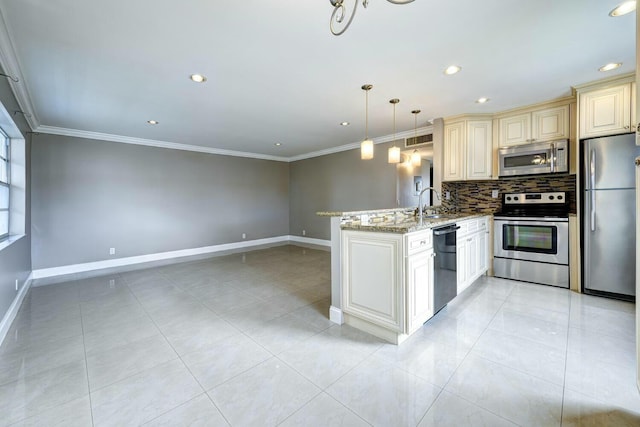 267 Normandy F, Delray Beach, FL 33484 - kitchen with cream cabinetry, a peninsula, ornamental molding, tasteful backsplash, and appliances with stainless steel finishes