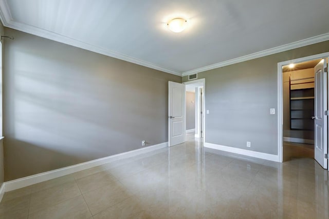 unfurnished bedroom featuring a spacious closet, crown molding, light tile patterned floors, and a closet