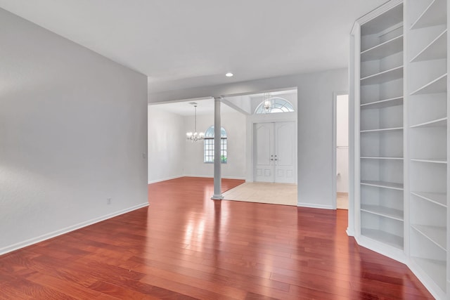 foyer with hardwood / wood-style floors, french doors, and a notable chandelier