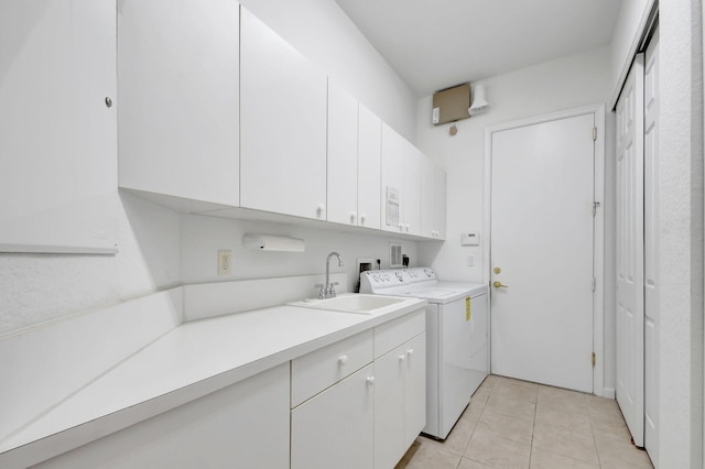 washroom with washer and dryer, sink, light tile patterned floors, and cabinets