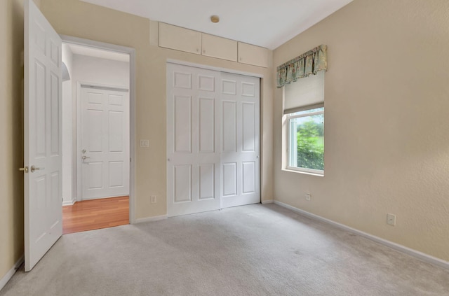 unfurnished bedroom featuring a closet and light colored carpet