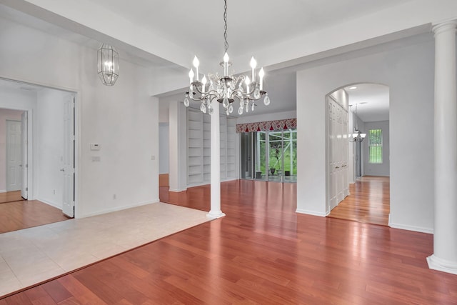 unfurnished dining area with hardwood / wood-style floors and a chandelier