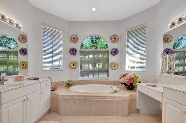 bathroom featuring tiled bath, tile patterned flooring, vanity, and plenty of natural light