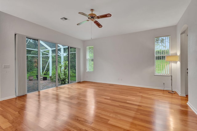 unfurnished room featuring ceiling fan, plenty of natural light, and light wood-type flooring