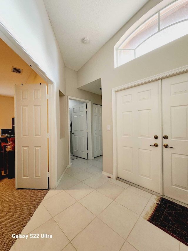 tiled foyer featuring lofted ceiling