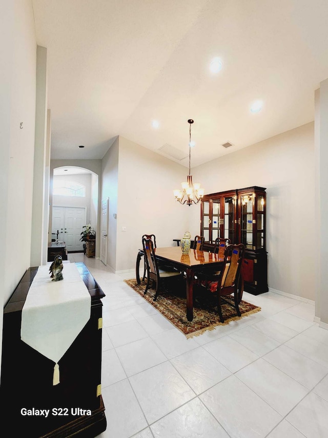 tiled dining room with a notable chandelier