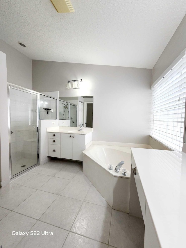 bathroom with vanity, tile patterned floors, shower with separate bathtub, and a textured ceiling