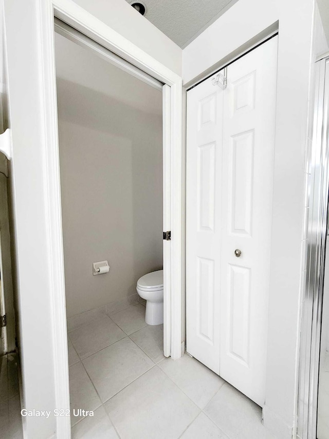 bathroom with tile patterned flooring and toilet