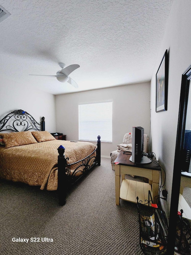 bedroom featuring ceiling fan, carpet floors, and a textured ceiling