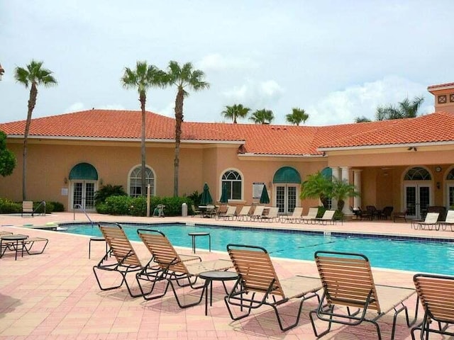 view of pool with french doors and a patio