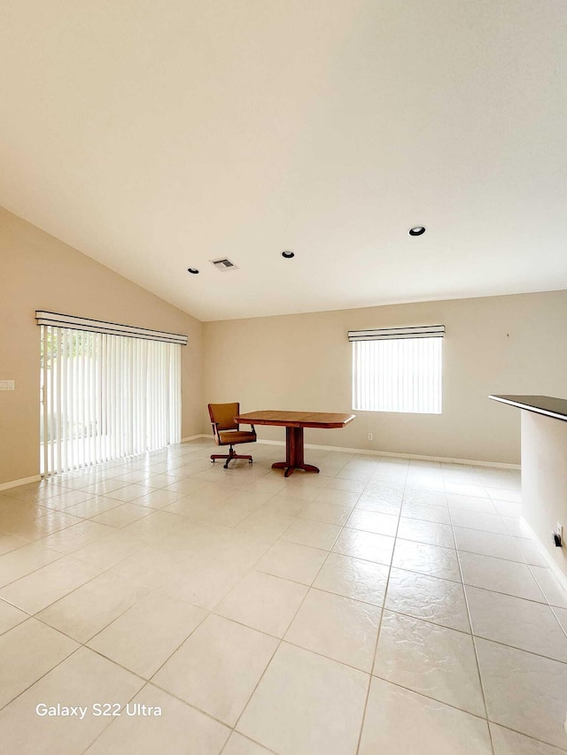 tiled spare room with vaulted ceiling