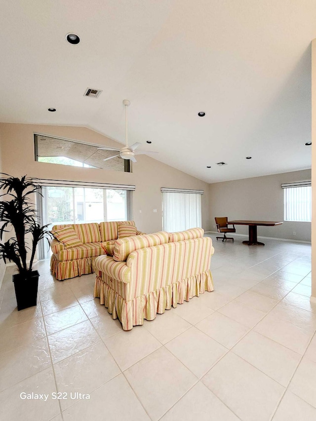 living room featuring lofted ceiling, light tile patterned floors, and plenty of natural light