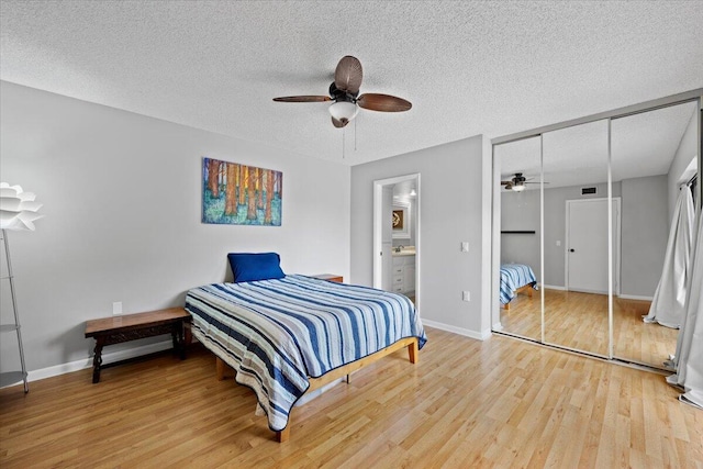 bedroom featuring ensuite bathroom, ceiling fan, a textured ceiling, wood-type flooring, and a closet