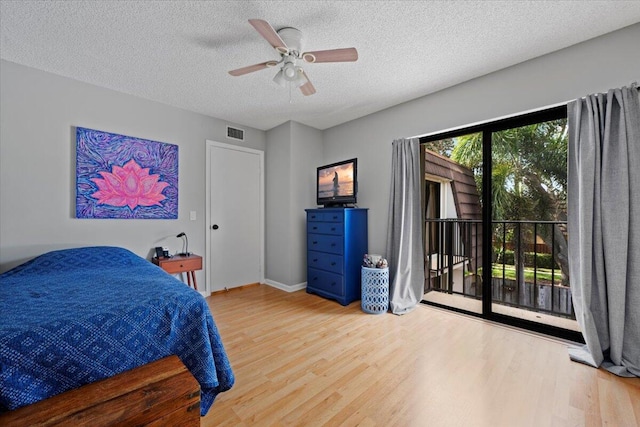 bedroom featuring hardwood / wood-style floors, a textured ceiling, access to outside, and ceiling fan