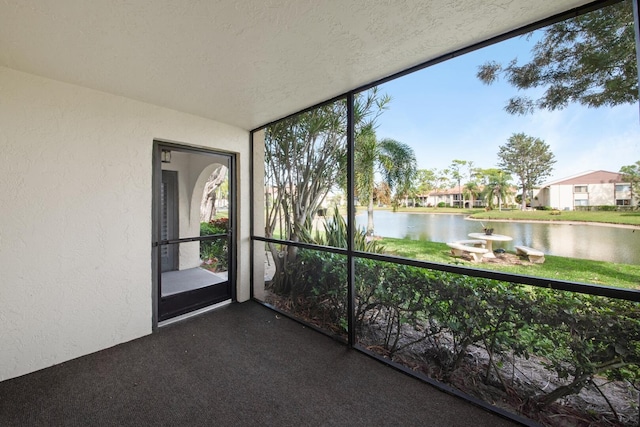 unfurnished sunroom featuring a water view