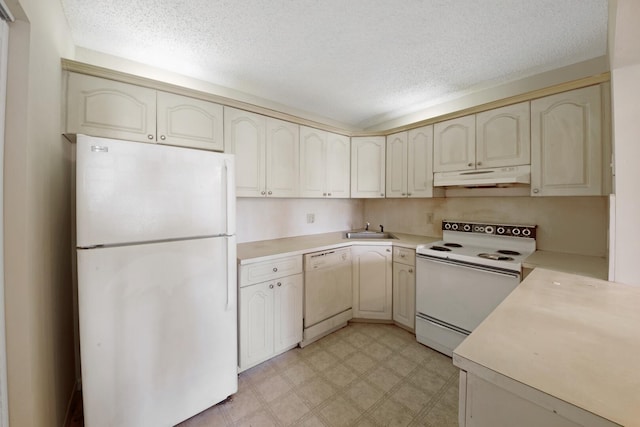 kitchen with sink, white appliances, a textured ceiling, and cream cabinetry